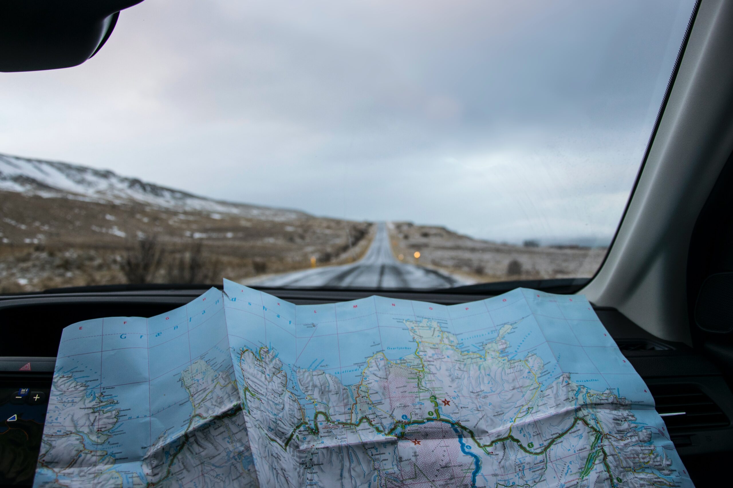 Picture of someone holding a roadmap in a car
